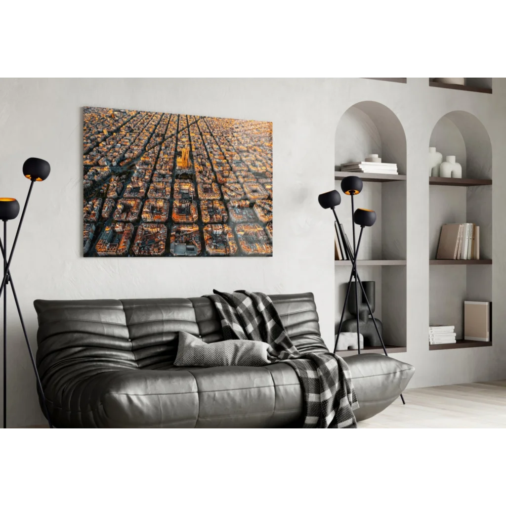 Modern black leather sofa with quilted texture and plaid throw, styled with glass wall art