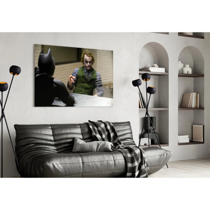 Black leather sofa with quilted texture and plaid throw near Batman Joker glass wall art