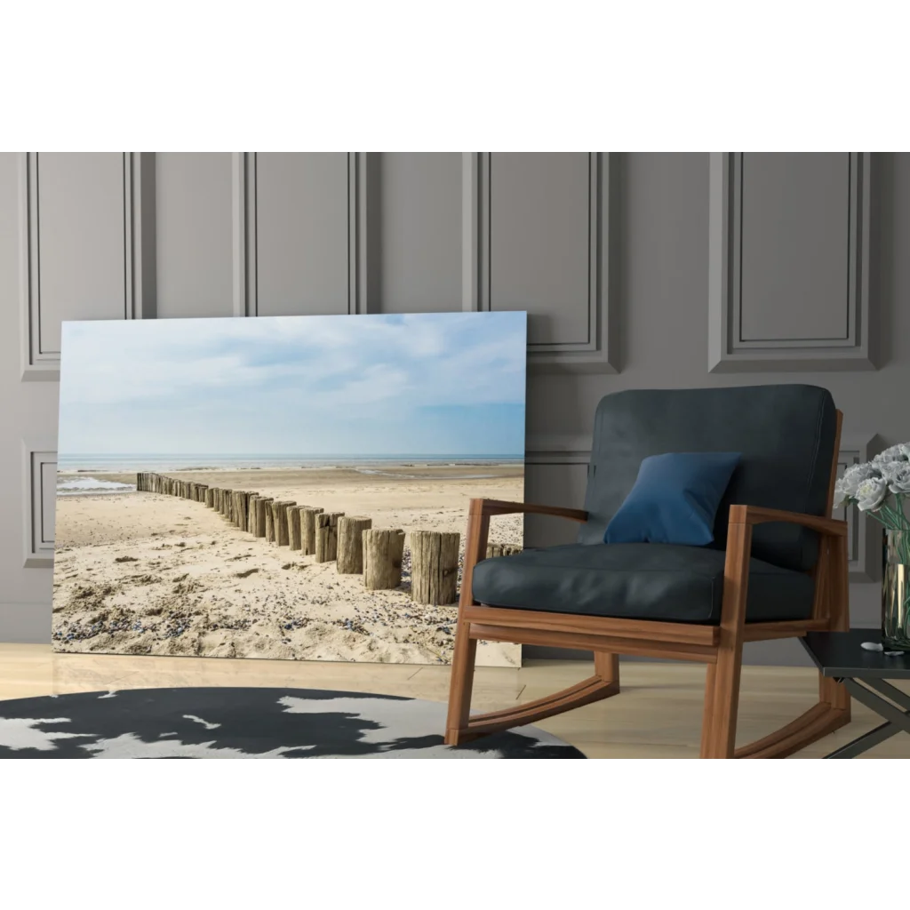 Coastal glass wall art print of beige blue beach scene leaning on gray wall