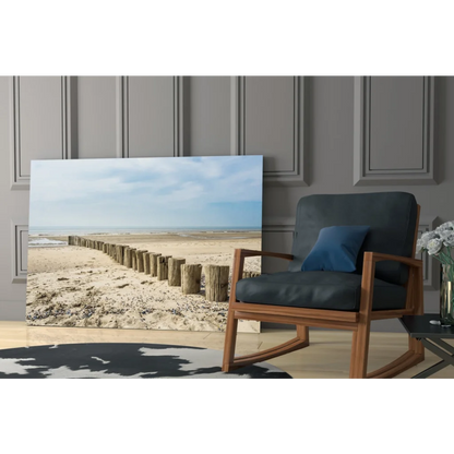 Coastal glass wall art print of beige blue beach scene leaning on gray wall