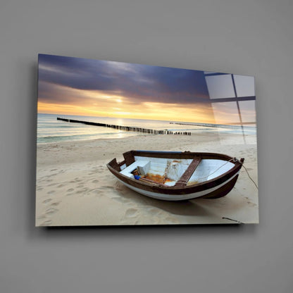 Weathered rowboat on beach at sunset glass wall art print