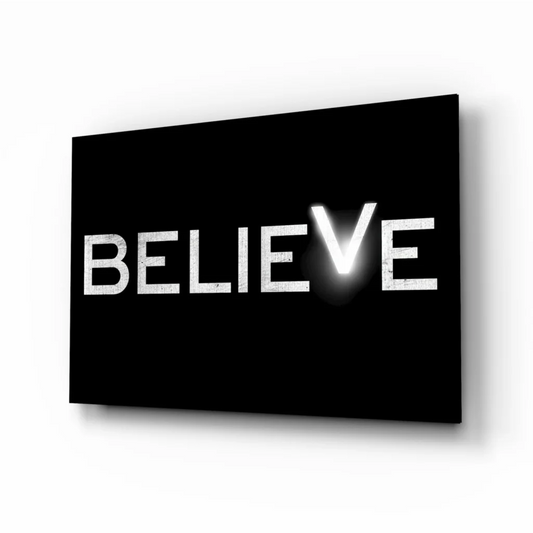 Black canvas wall art with bold Believe text in glowing white