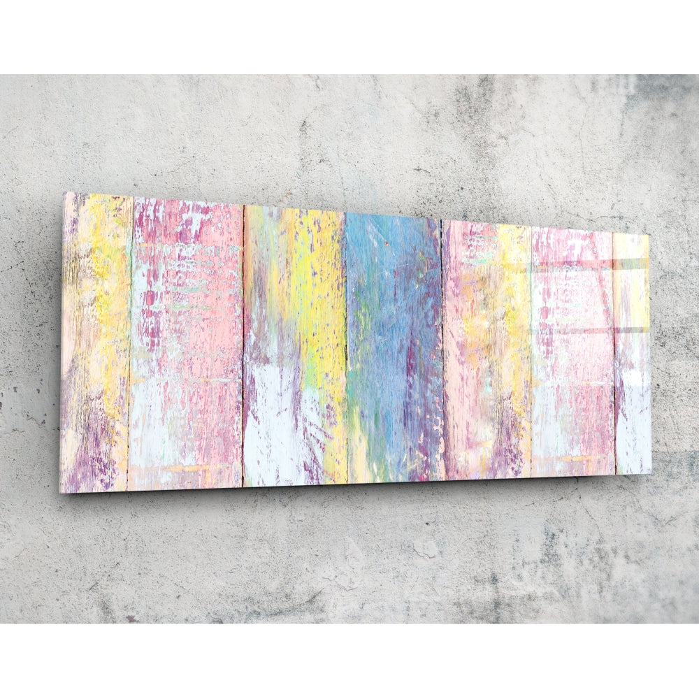 Overhead view of a horizontal wooden wall art piece with nine painted panels in pastel pink, yellow, blue, and white with distressed finishes on concrete background.