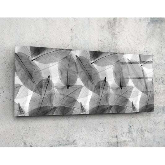 Black and white leaf-patterned glass panel mounted on textured concrete wall, displayed horizontally.
