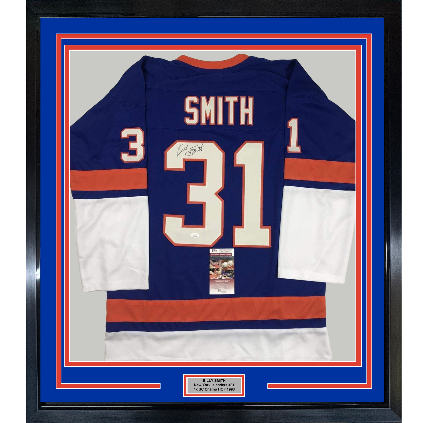 Framed navy blue New York Islanders #31 hockey jersey with red and white stripes, signed by Billy Smith, displayed against blue matting with authentication certificate visible.