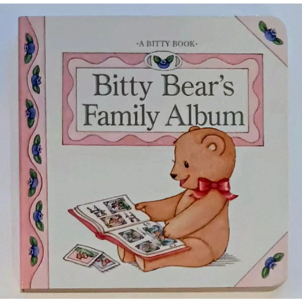 Bitty Baby board book cover: teddy bear in red bow tie holds family album photos