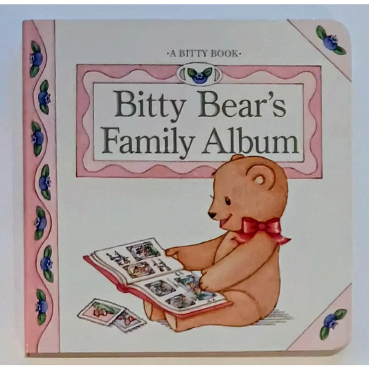 Bitty Baby board book cover: teddy bear in red bow tie holds family album photos