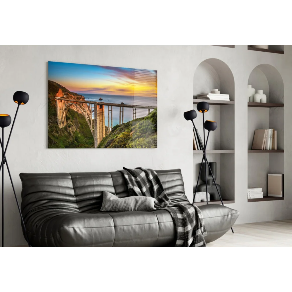 Black leather sofa with plaid blanket under Bixby Bridge sunset wall art