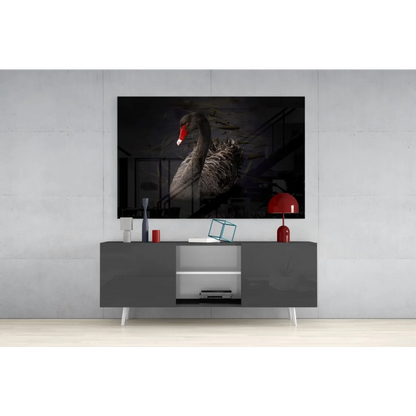 Dramatic black swan glass wall art with bold red beak on gray console