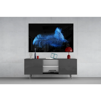 Striking glowing blue feather glass wall art on black canvas atop gray console