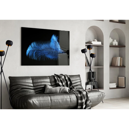 Glowing blue feather glass wall art on black canvas above sofa