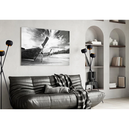 Black and white longtail boat beach canvas wall art above gray sofa