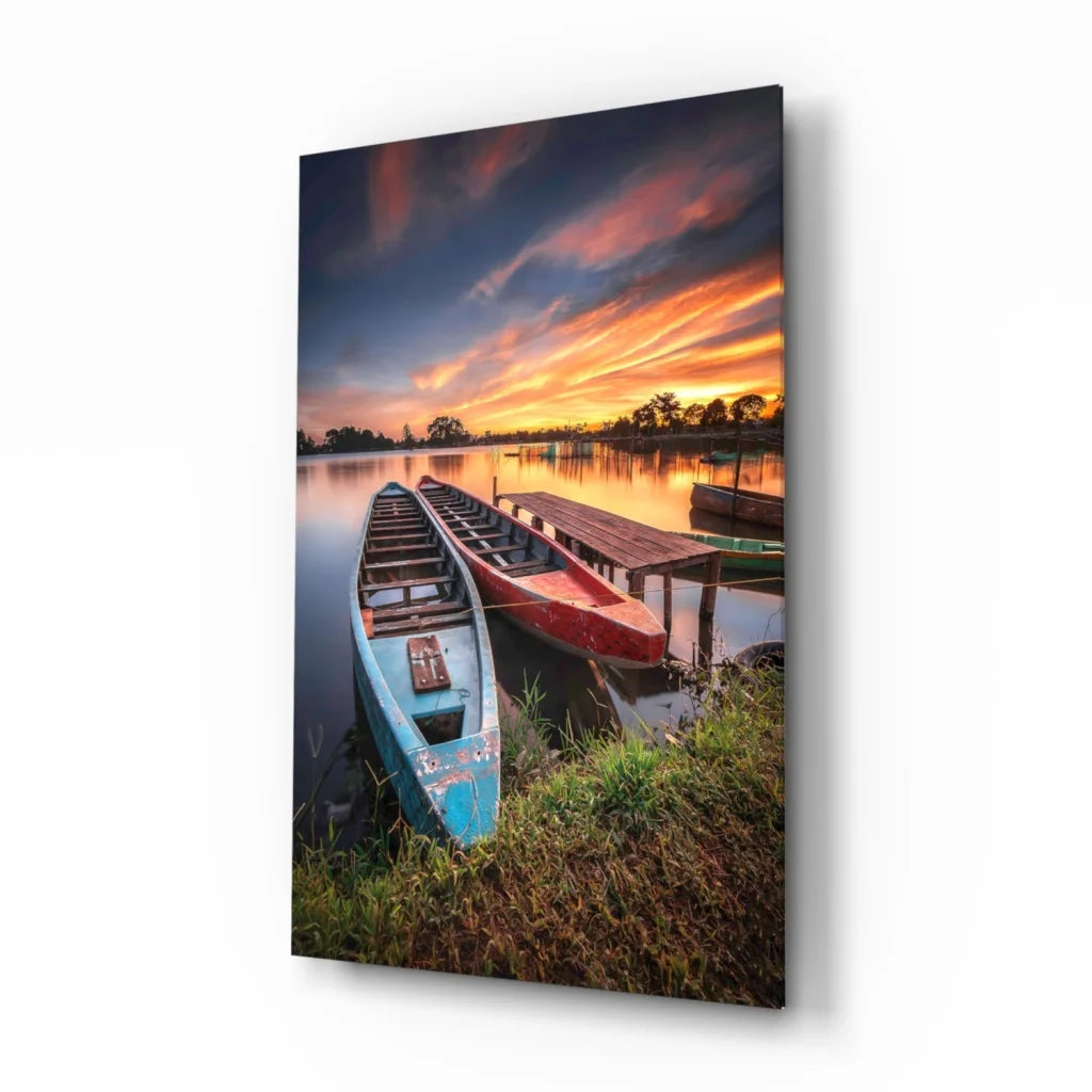 Vibrant lakeside sunset glass wall art with red canoe on weathered pier