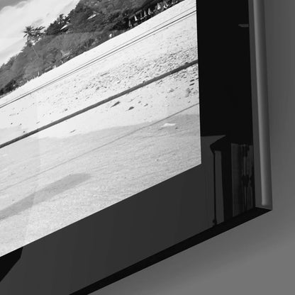 Black-and-white beach boats glass wall art print in black frame