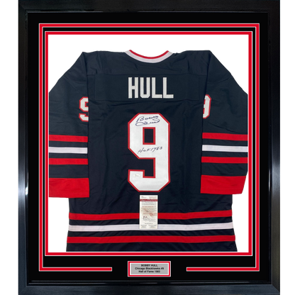 Framed Chicago Blackhawks jersey number 9 with "HULL" nameplate, navy with red and white stripes, displaying autograph and JSA authentication certificate.