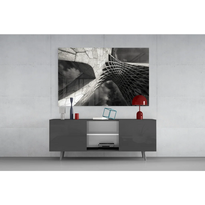 Modern gray sideboard with sleek legs and open compartments below bold geometric glass wall art