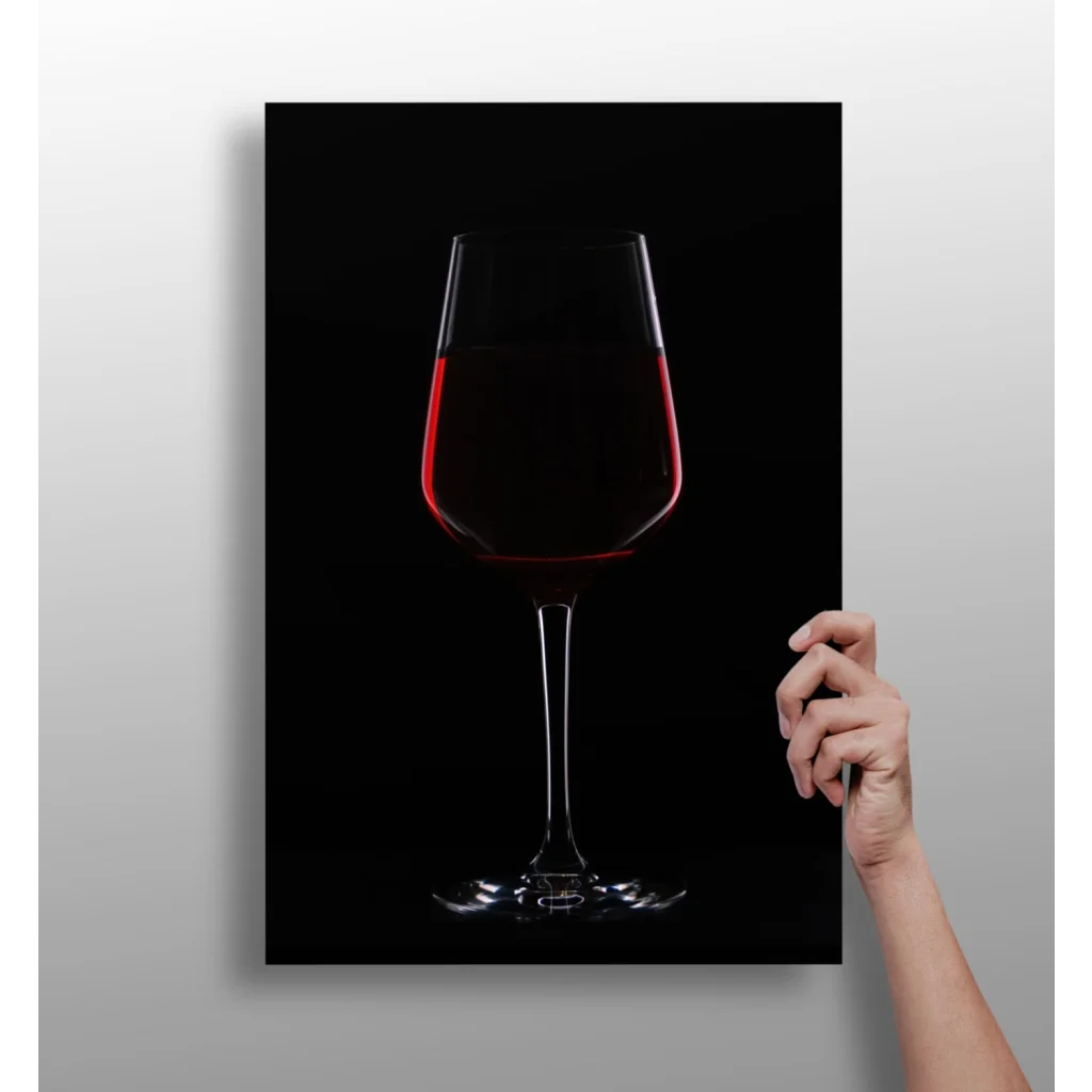 Sleek transparent wine glass with bold red wine on black background canvas print