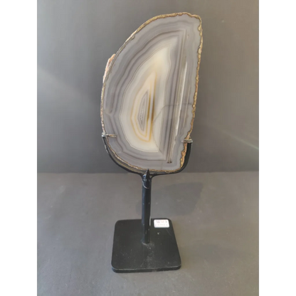 Polished gray and white Brazilian agate slice on metal display stand