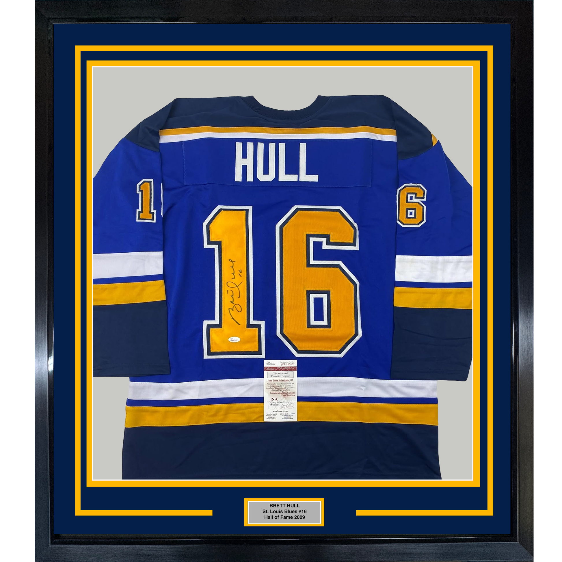 Framed blue St. Louis Blues hockey jersey number 16 with "HULL" nameplate and autograph, displayed front-facing with yellow and white stripes.