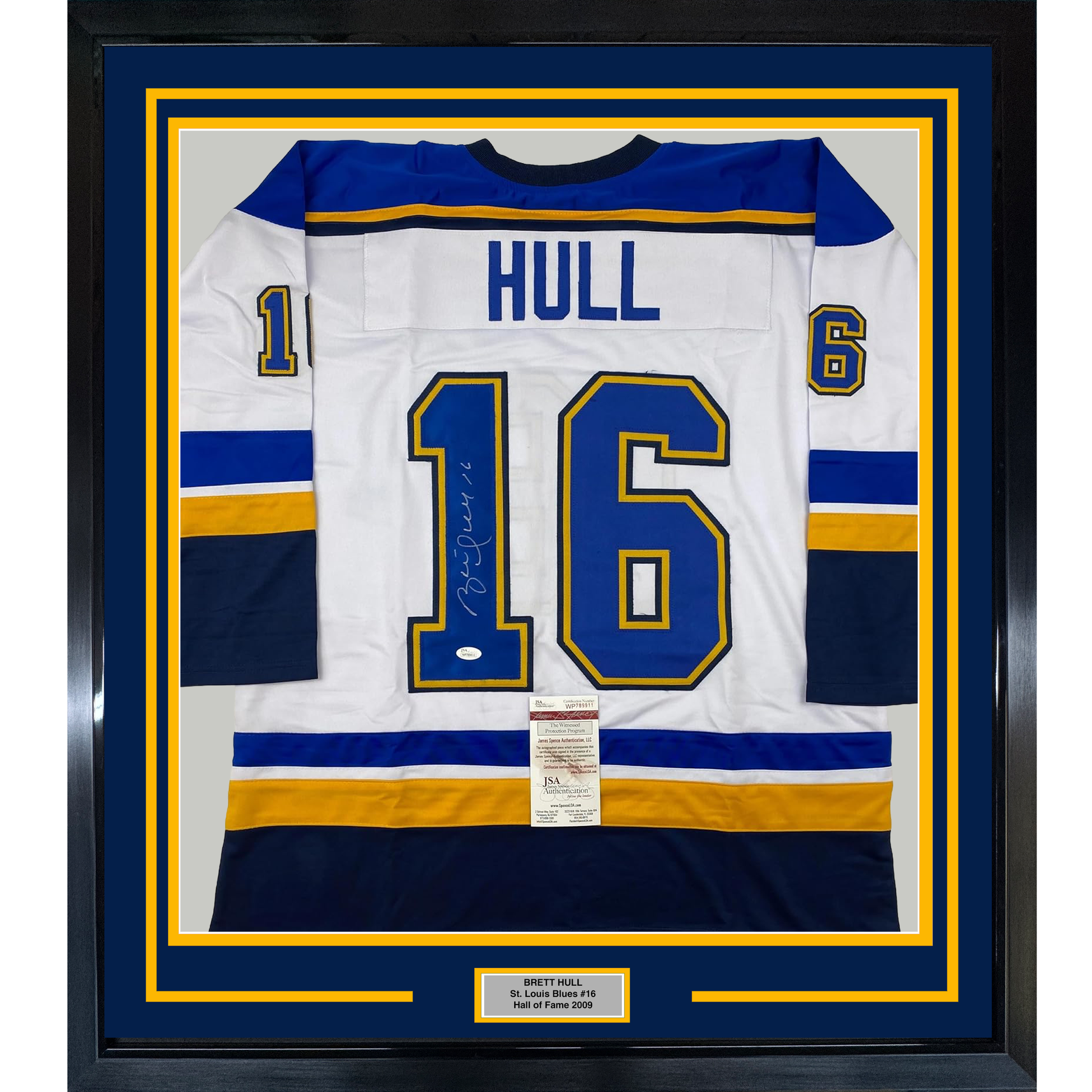 Framed St. Louis Blues #16 white hockey jersey with "HULL" name and blue/gold numbers, signed, displayed against blue and gold matting with authentication certificate.