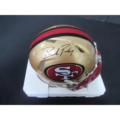Gold San Francisco 49ers mini helmet with red stripe and Brock Purdy autograph