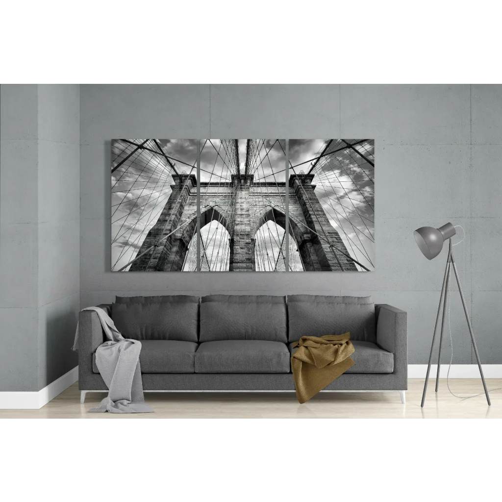 Black and white Brooklyn Bridge triptych wall art canvas print above gray sofa