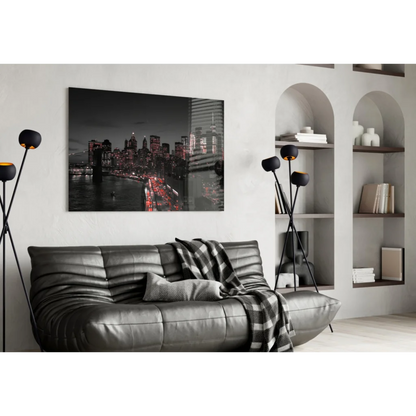 Black leather sofa with plaid throw and Brooklyn Bridge wall art