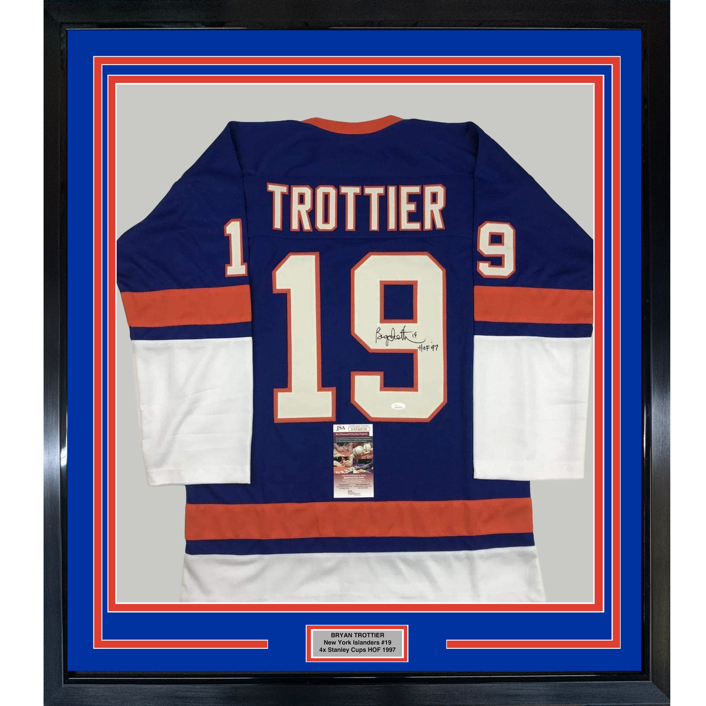 Framed navy blue hockey jersey #19 with "TROTTIER" nameplate, signed, displayed front-facing with red and white stripes and authentication certificate mounted below.