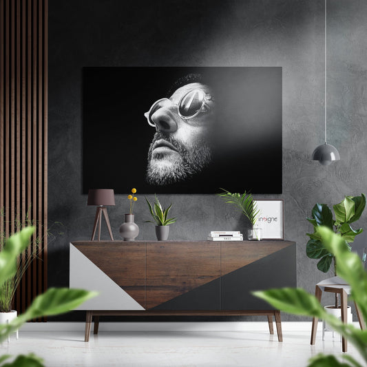 Black and white portrait of bearded man wearing sunglasses displayed on brushed aluminum wall art above wooden console in modern interior setting.