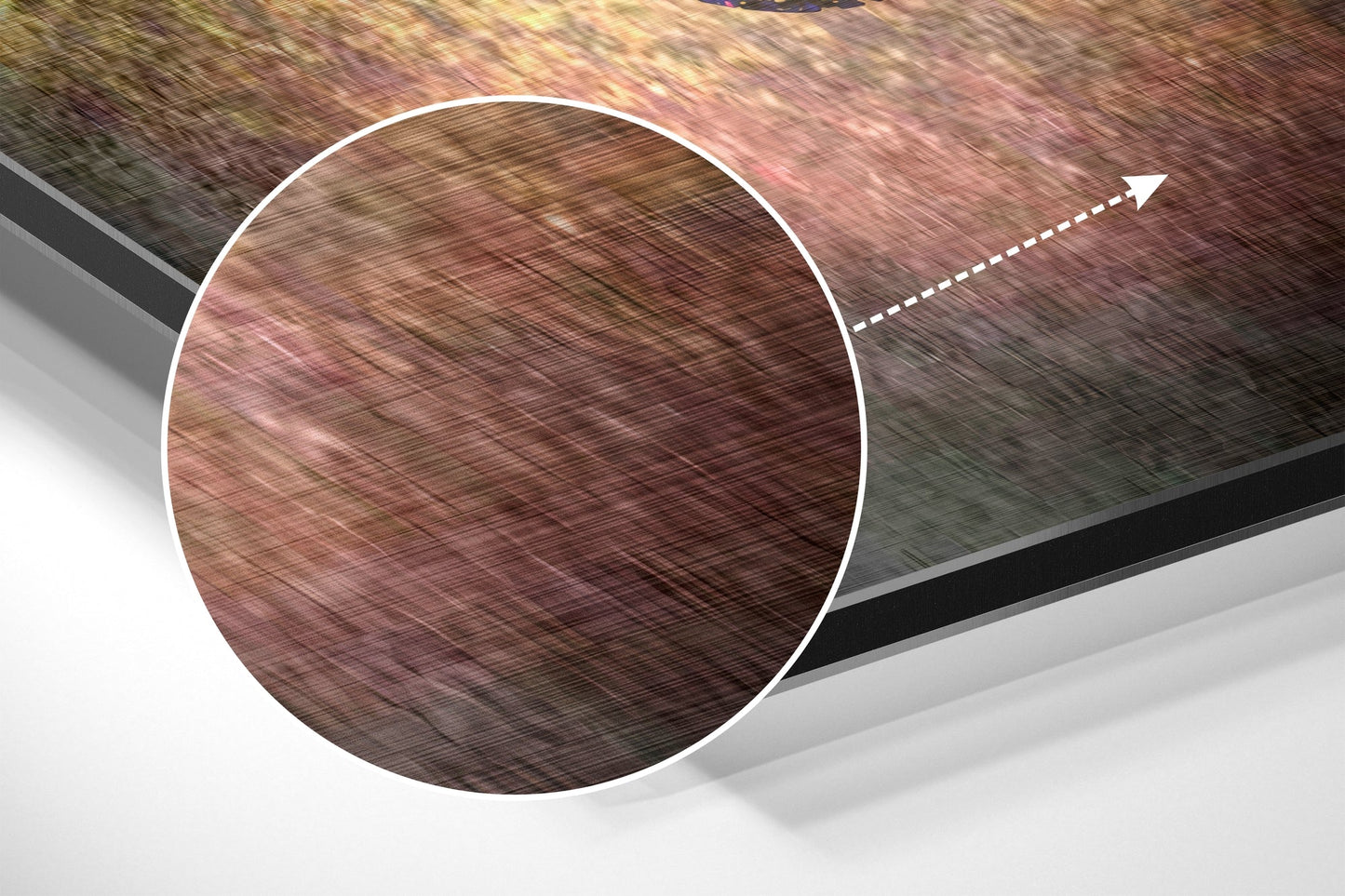 Close-up angled view of brushed aluminum wall art showing textured brown and pink tones with directional arrow detail.