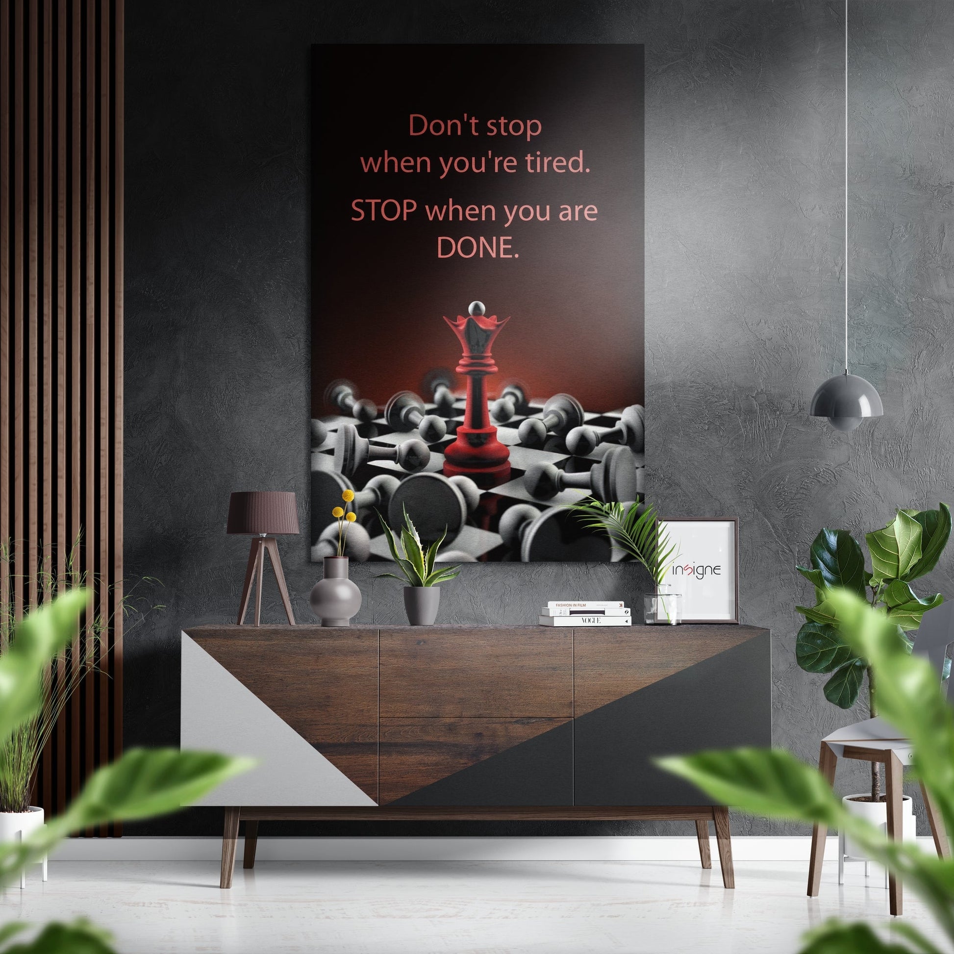 Modern interior styling shot featuring motivational wall art with red queen chess piece and gray pawns, displayed above wooden console table with plants and accessories.