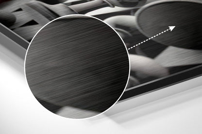 Close-up detail of brushed aluminium surface with horizontal line texture and white circular frame with directional arrow overlay.