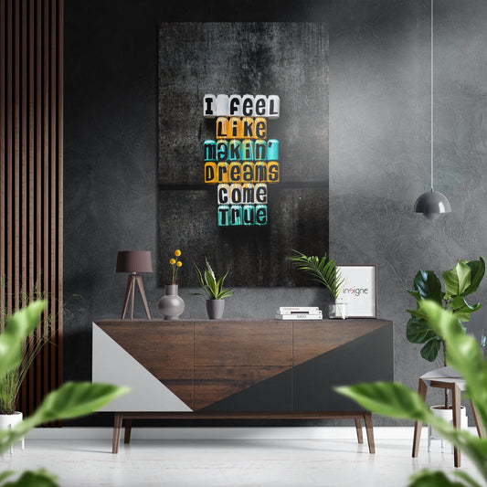 Neon-style wall art with stacked colored text reading "I need like making dreams come true" mounted above a wooden dresser in a modern interior setting.