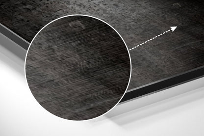 Angled close-up view of a circular brushed aluminum disc with directional arrow, showing metallic texture and grayscale tones.