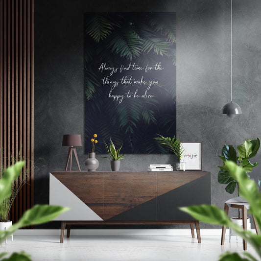Modern interior with motivational wall art featuring green foliage and white handwritten text above wooden dresser with plants.