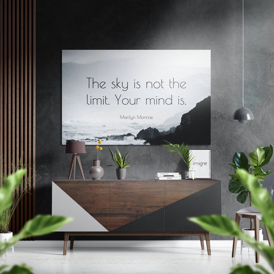 Modern living room display featuring a Marilyn Monroe quote on brushed aluminum wall art above a wooden credenza with decorative items and plants.