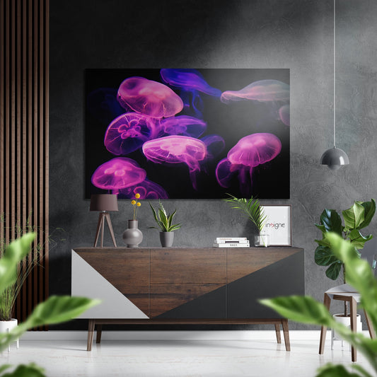 Brushed aluminium Dibond wall art displaying neon pink and purple glowing jellyfish against black background, mounted above wooden dresser in modern interior.