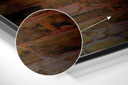 Close-up detail of brushed aluminum dibond wall art showing wood grain texture with warm brown and green tones and horizontal striations.