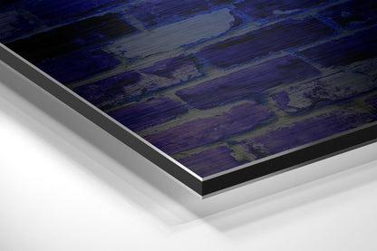 Close-up angled view of layered Dibond wall art with dark blue and purple brushed metal surface and aluminum edge detail.