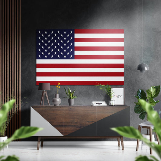 American flag wall art displayed above a wooden console table in a modern interior with plants and pendant lighting.