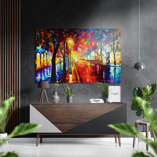 Vibrant street scene artwork with glowing trees and wet pavement in reds, blues, and yellows displayed above a wooden dresser in a modern interior.