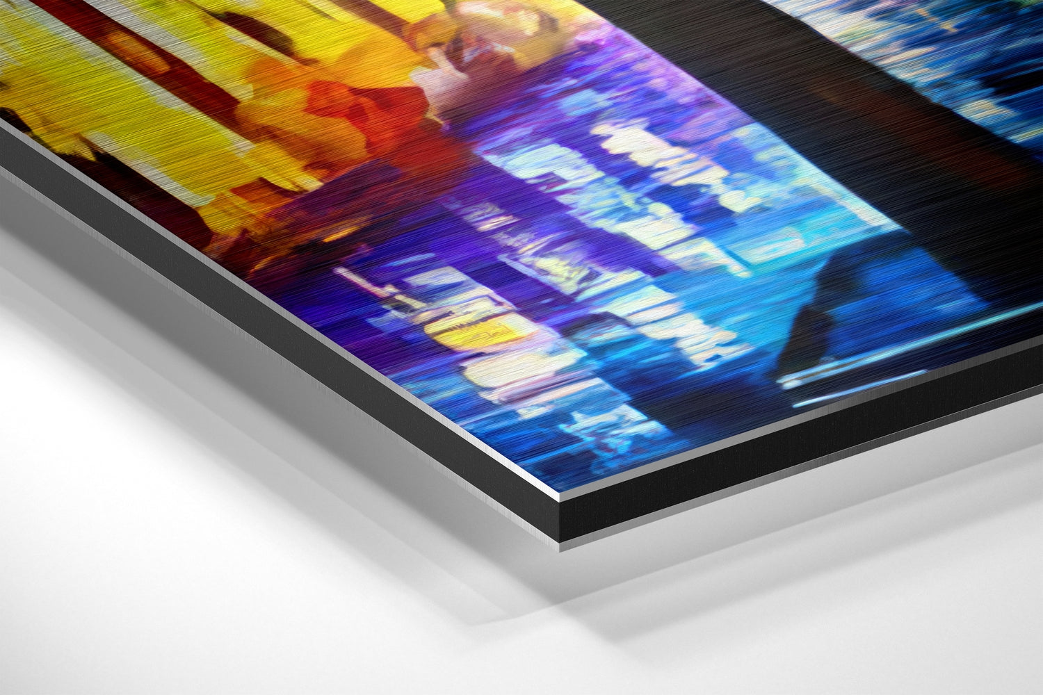 Angled view of framed aluminum wall art displaying colorful nighttime street scene with yellow, red, purple, and blue tones.