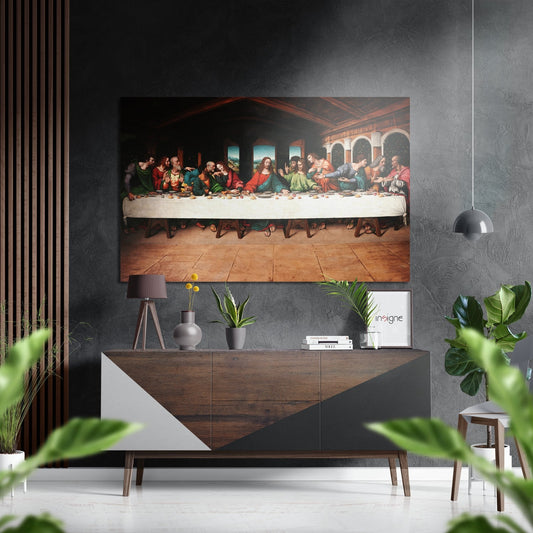 Last Supper brushed aluminium wall art displayed above a wooden console table in a modern interior with potted plants and pendant lighting.