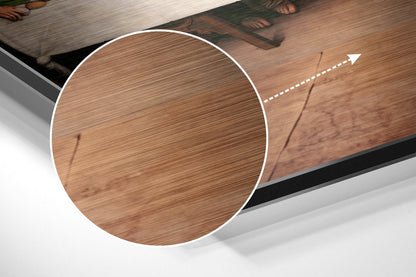 Close-up circular detail of brushed wood-grain surface with white border and directional arrow on angled Last Supper wall art.