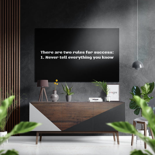 Modern living room with motivational wall art displaying "There are two rules for success: 1. Never tell everything you know" on black screen above wooden console table with plants and décor.