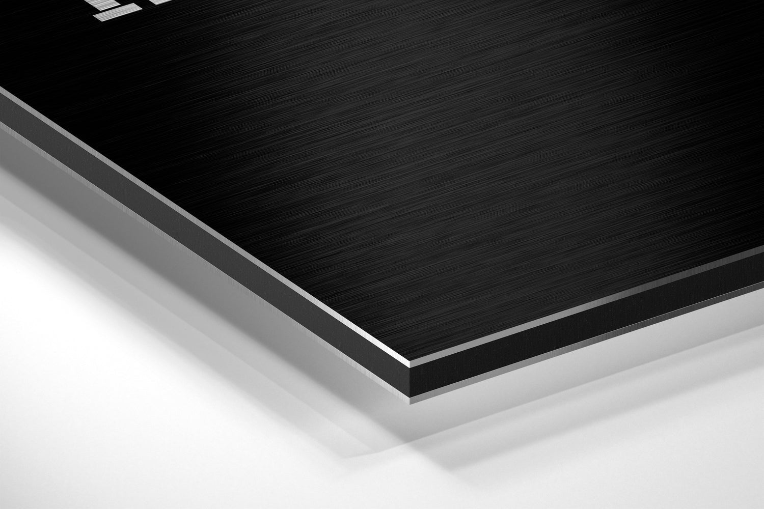 Close-up angled view of layered brushed aluminum and black composite materials showing edge detail and surface texture.
