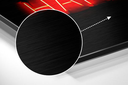 Large white-outlined black circle on brushed aluminum surface with red neon sign and directional arrow above.