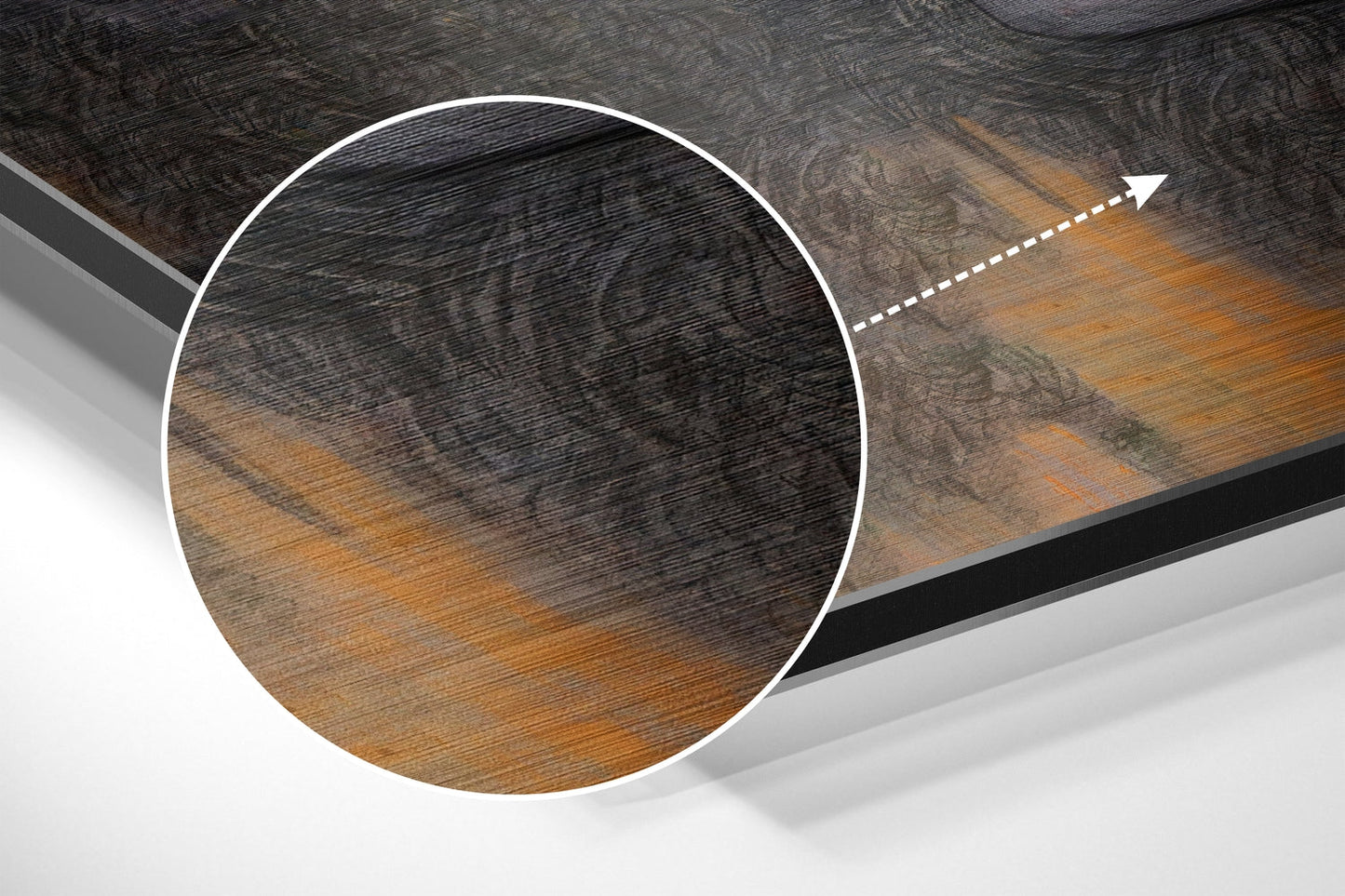 Close-up circular detail of brushed aluminium Dibond wall art showing wood grain texture with black and golden brown tones and directional arrow indicator.