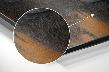 Close-up circular detail of brushed aluminium Dibond wall art showing wood grain texture with black and golden brown tones and directional arrow indicator.