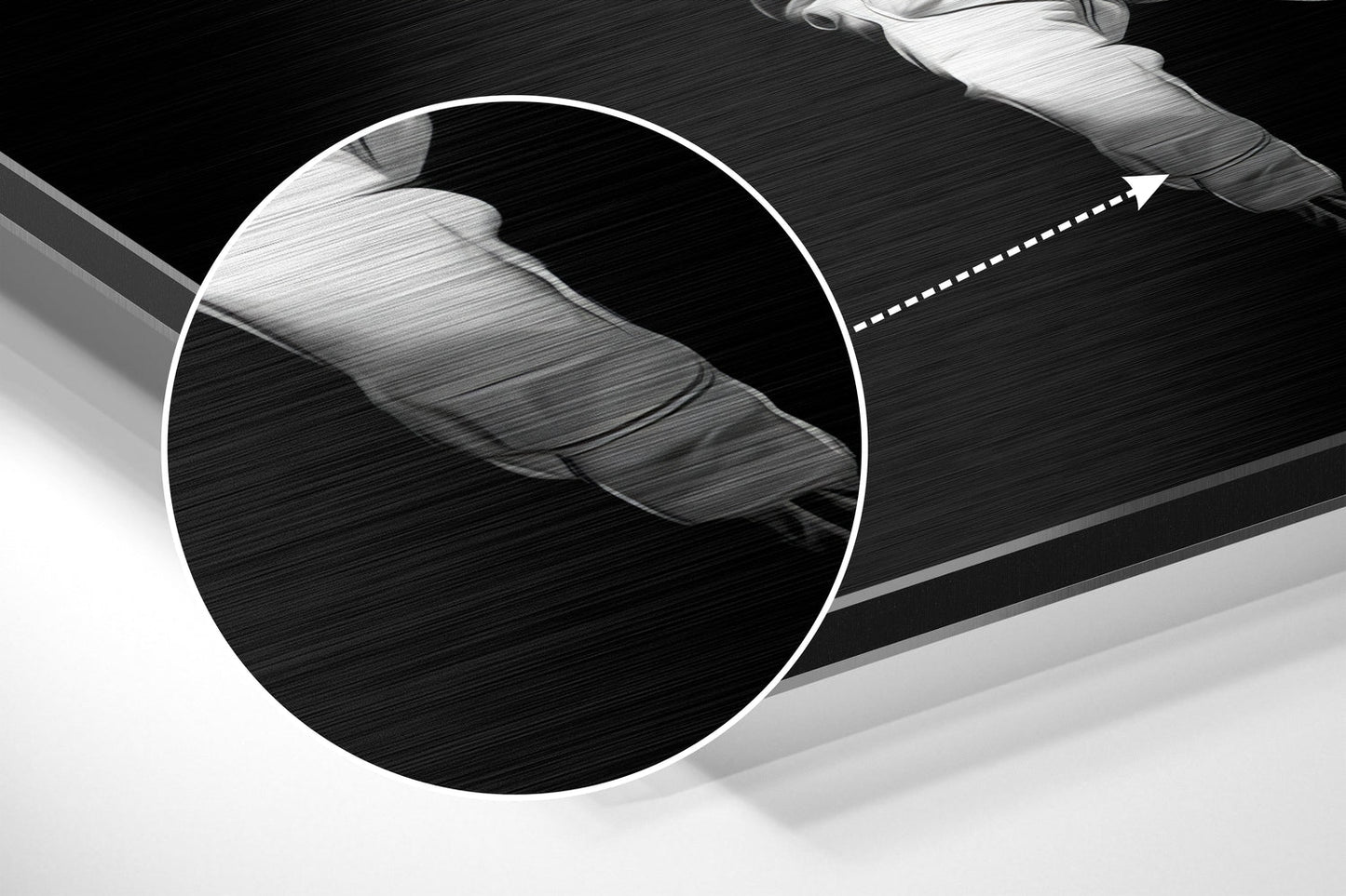 Close-up detail of brushed aluminum surface showing textured finish and white circular magnified section highlighting material grain pattern.